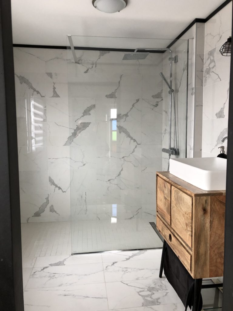 Salle de bains moderne en marbre avec meuble en bois massif